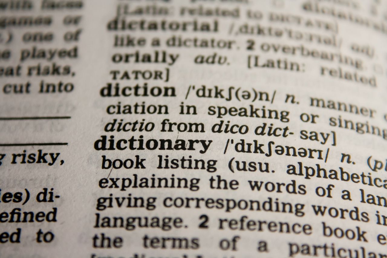 about-us-01 Detailed close-up view of a dictionary page highlighting the word 'dictionary' and its definition.