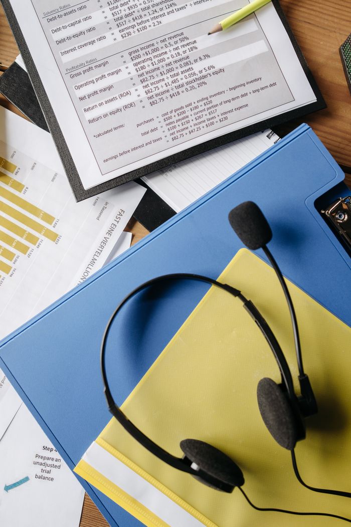 heros-img A neat flat lay of a call center desk setup featuring documents, charts, and a headset.